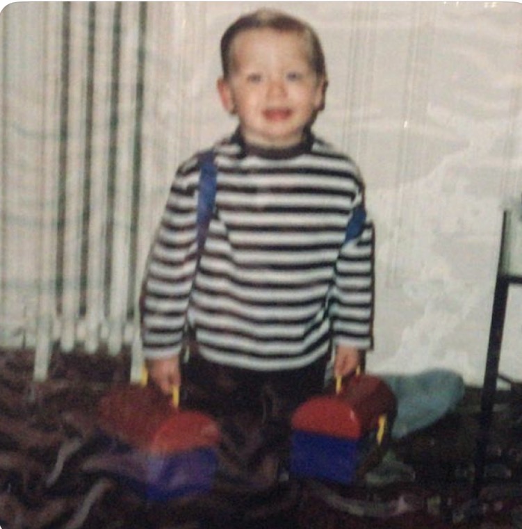 Freddie as a young boy, smiling with toys