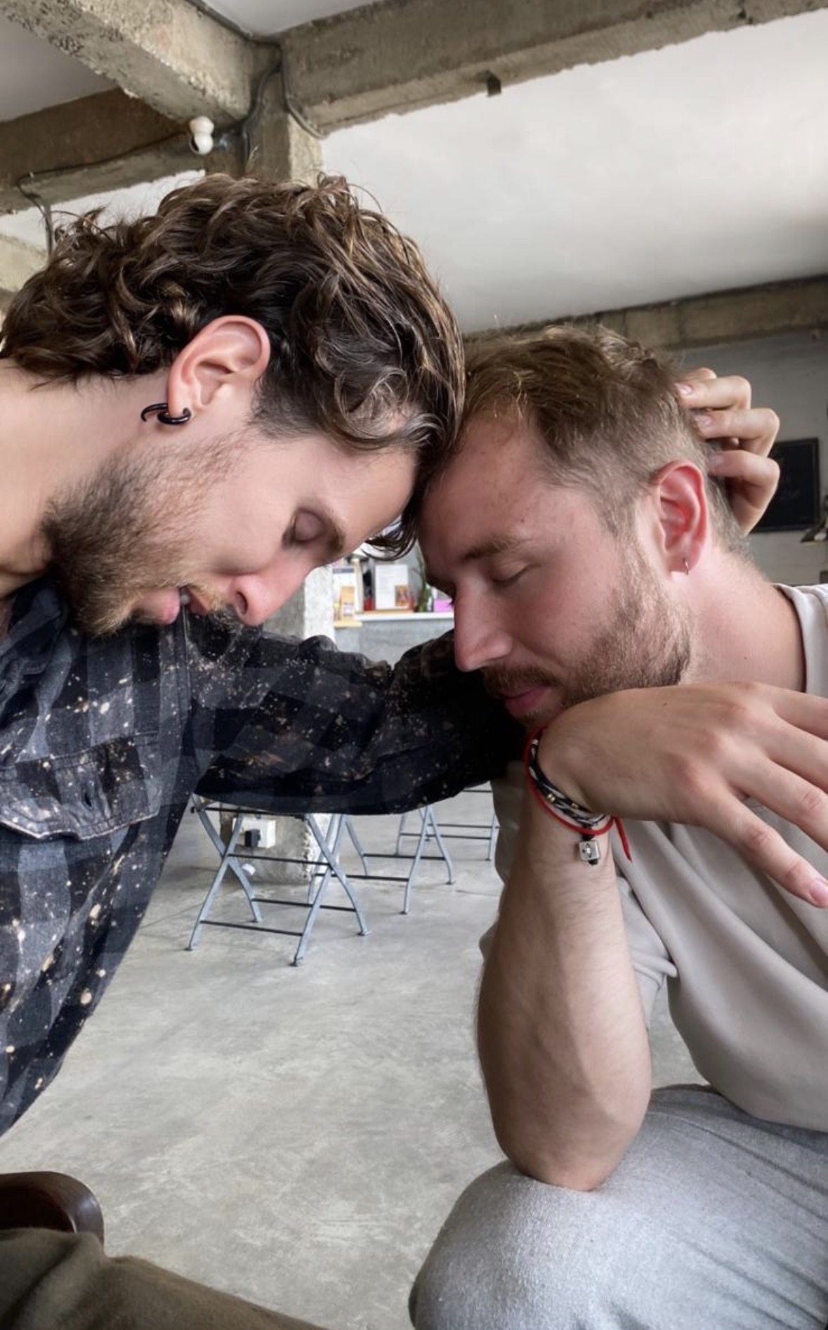 Two men resting head to head in quiet brotherhood